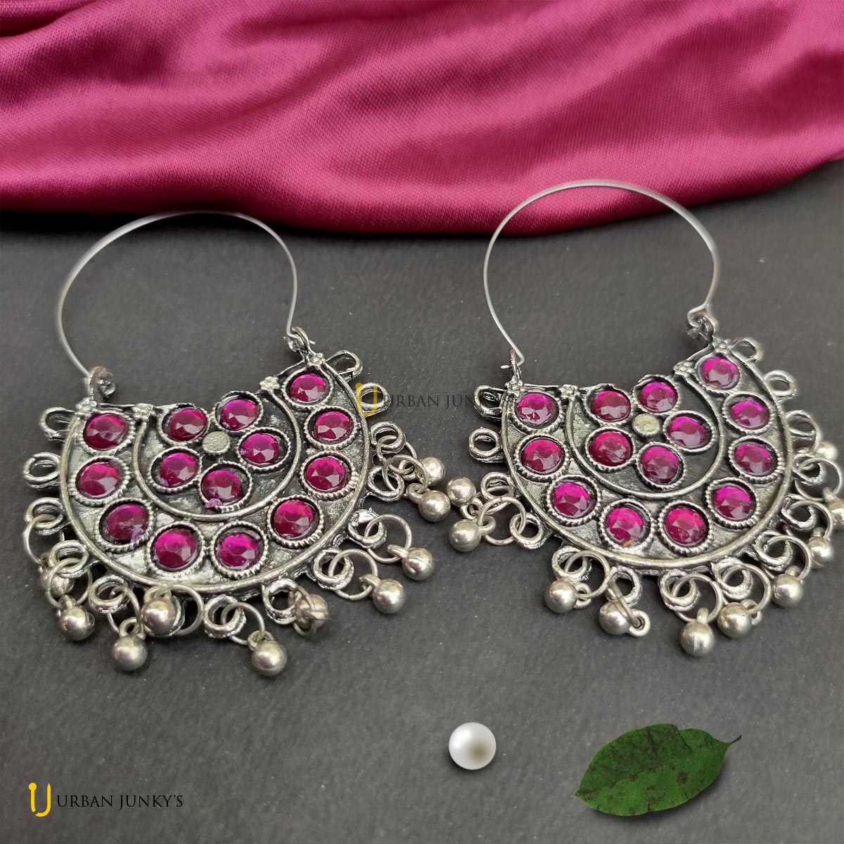 This is a pair of pink stone studded earring. It is having small hanging silver coloured balls. This is a pair of pink stone studded earring. It is having small hanging silver coloured balls.