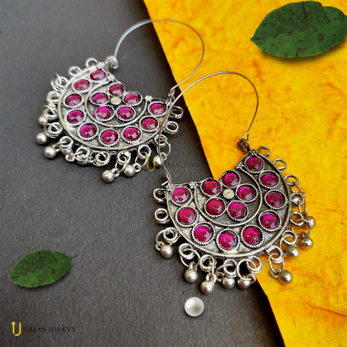 This is a pair of pink stone studded earring. It is having small hanging silver coloured balls. This is a pair of pink stone studded earring. It is having small hanging silver coloured balls.